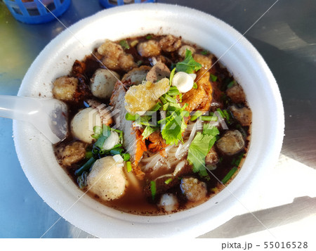 Close up of a bowl of Thai style pork noodle soup. 55016528
