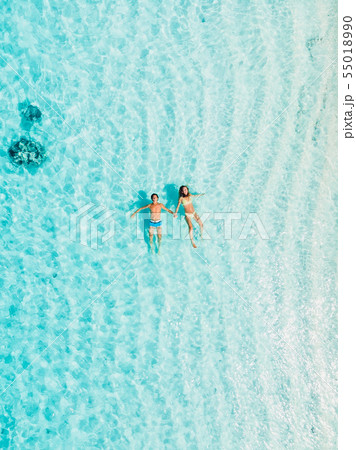 Pregnant woman with husband swim in blue sea 55018990