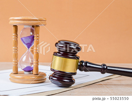 Judge's gavel with hourglass on the table. 55023550