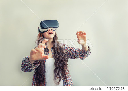 Smile young woman wearing using virtual reality VR glasses helmet headset on white background 55027293