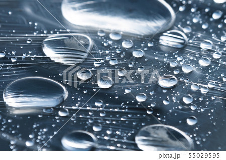 Close-up of raindrops of different sizes on the surface covered with cling film. Moisture weather 55029595