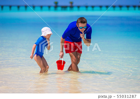 Happy father and little daughter have fun on tropical beach Happy father and little daughter have fun on tropical beach 55031287