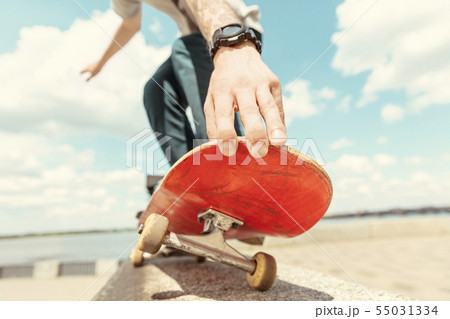 Skateboarder doing a trick at the city's street in sunny day 55031334