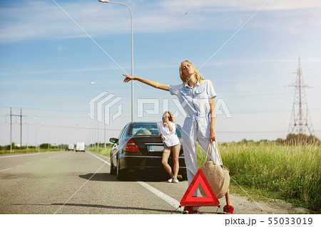 Young lesbian's couple going to vacation trip on the car in sunny day Young lesbian's couple going to vacation trip on the car in sunny day 55033019