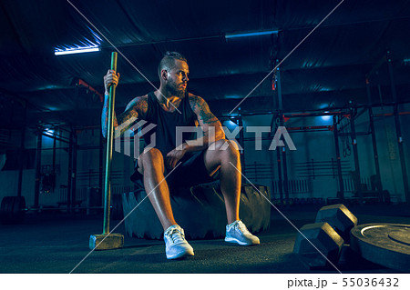 Young healthy man athlete doing exercise in the gym Young healthy man athlete doing exercise in the gym 55036432