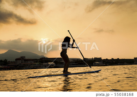 Silhouette of a beautiful woman on Stand Up Paddle Board. SUP Silhouette of a beautiful woman on Stand Up Paddle Board. SUP 55038168
