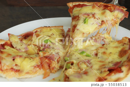Hawaiian Pizza lifted slice on white dish. Hawaiian Pizza lifted slice on white dish. 55038513
