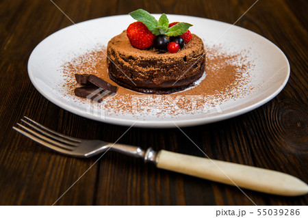 Chocolate fondant lava cake decorated with strawberries and cocoa powder 55039286