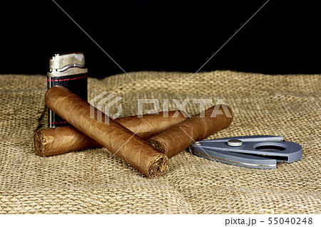 Cuban cigars with a cutter and a lighter on a Cuban cigars with a cutter and a lighter on a 55040248