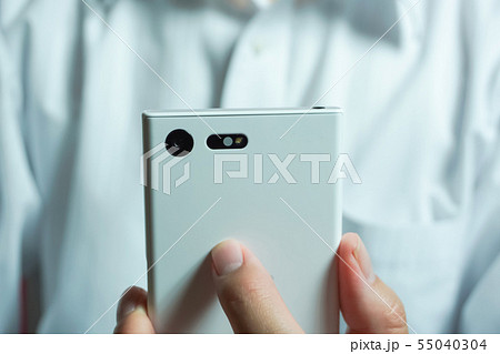 スマートフォンを見ている人　ワイシャツを着た人物の背景 55040304