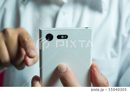 スマートフォンを見ている人　ワイシャツを着た人物の背景 55040305