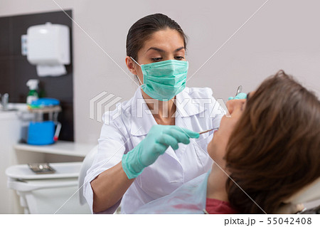 Doctor examining the oral cavity of a teenager 55042408