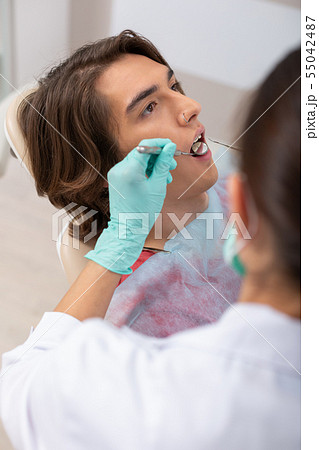 Relaxed young patient sitting in a dental chair 55042487