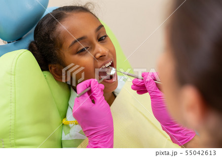 Pretty young female patient sitting with an open mouth 55042613