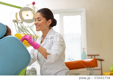 Middle-aged Caucasian female dentist performing a dental exam 55042758
