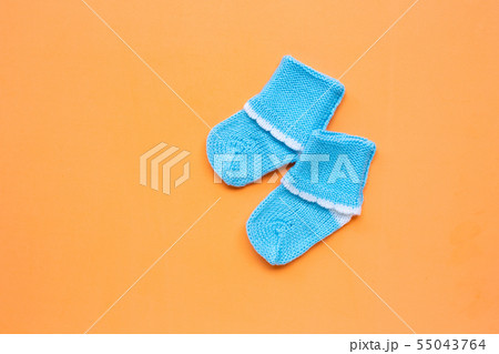 Baby socks on orange background.  55043764