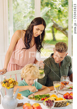 Caring mommy watching son eating in summer house Caring mommy watching son eating in summer house 55043823