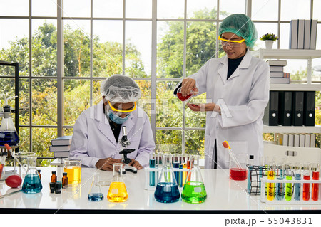 Two scientists research new chemical item 55043831