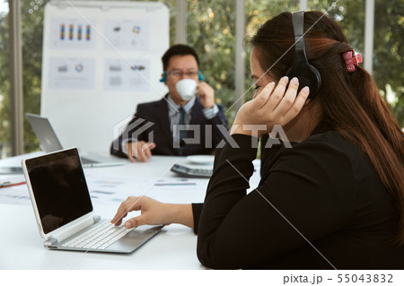 Senior secretary listen music while searching data 55043832