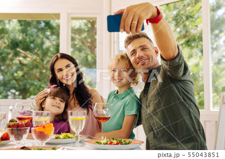 Husband taking his smartphone while making selfie with family 55043851