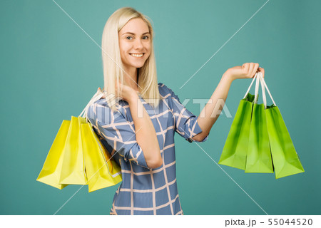 Happy girl in a checkered blouse holds shopping 55044520