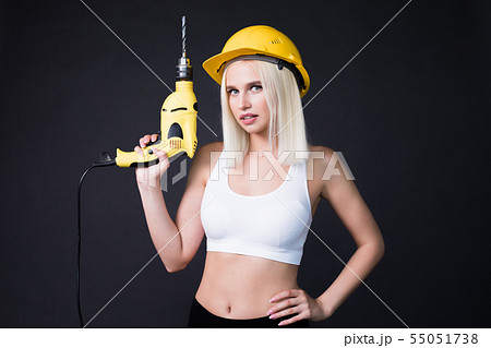 Sexy woman with a drill. Woman builder in construction helmet. 55051738