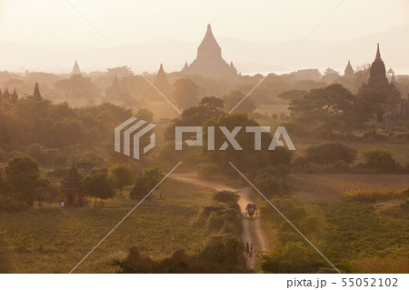 Orange mystical sunrise landscape view with silhouettes of old ancient temples and palm trees in 55052102