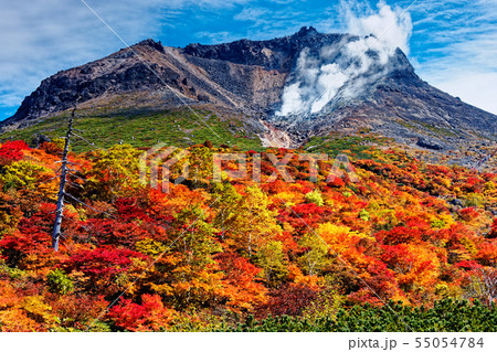 那須連峰 姥ヶ平の紅葉と噴煙上げる茶臼岳の写真素材