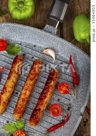 Kupaty in a frying pan, vegetables and spices. Kupaty in a frying pan, vegetables and spices. 55064955