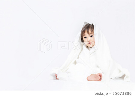 白背景で白いバスタオルを被り遊ぶ女の子の赤ちゃん。幸せ,愛情,赤ちゃん,育児イメージ 55073886