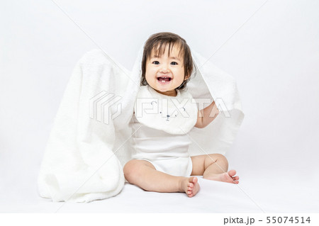 白背景で白いバスタオルを被り遊ぶ女の子の赤ちゃん。幸せ,愛情,赤ちゃん,育児イメージ 55074514