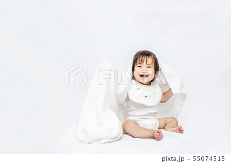 白背景で白いバスタオルを被り遊ぶ女の子の赤ちゃん。幸せ,愛情,赤ちゃん,育児イメージ 55074515