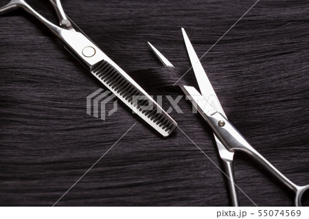 Hairdresser scissors cut dark hair. Scissors and Hairdresser scissors cut dark hair. Scissors and 55074569