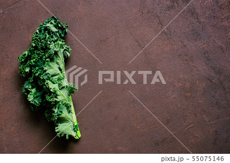Brown textured background with fresh kale Brown textured background with fresh kale 55075146