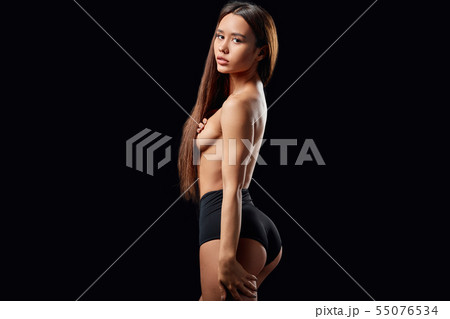 shirtless woman with palms on her breasts looking back 55076534