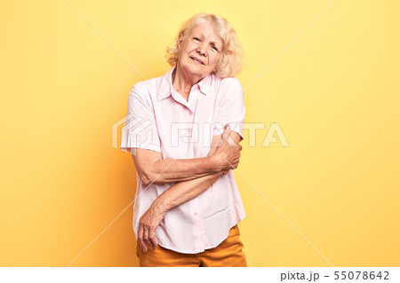 elderly beautiful woman touches her arm 55078642