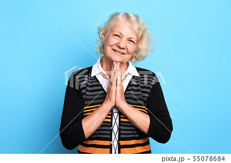 Senior happy blonde woman pressing palms together, praying the God 55078684