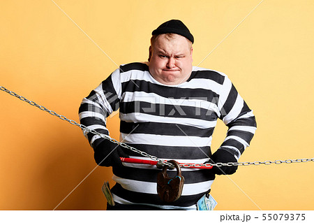 nervous prisoner making effort to cut the chain 55079375