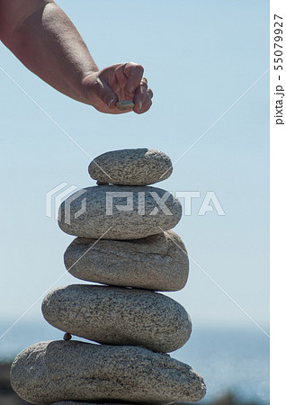 Closeup of woman putting pebble on stone balance  55079927