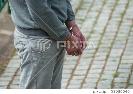 Closeup of hands of man handcuffed in the street Closeup of hands of man handcuffed in the street 55080040