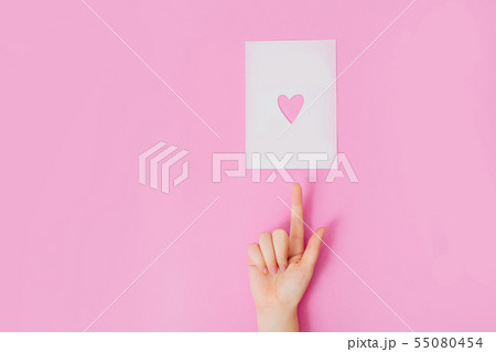 Female hand on a pink background pointing up. 55080454