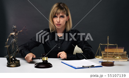 A young fair woman judge works in her office. A young fair woman judge works in her office. 55107139