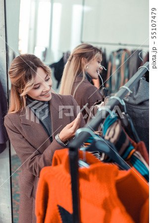 Appealing woman smiling after finding amazing dress Appealing woman smiling after finding amazing dress 55107479