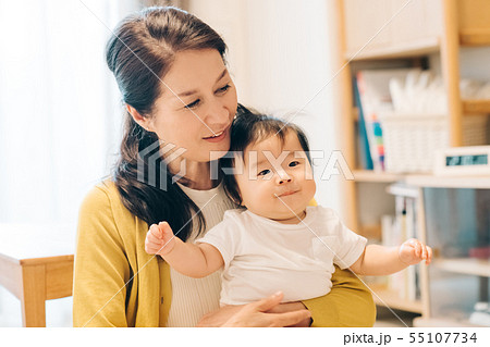 孫をあやす祖母 赤ちゃんとお婆ちゃん リビングルームの写真素材