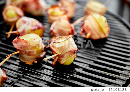 Grilled potato with bacon on gas grill . Grilled potato with bacon on gas grill . 55108128