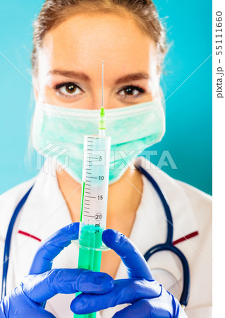 doctor in mask holding syringe with injection 55111660