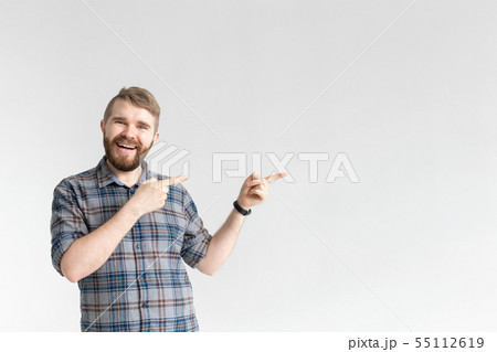 Happy funny young hipster man with a mustache posing on a white background and pointing on right Happy funny young hipster man with a mustache posing on a white background and pointing on right 55112619