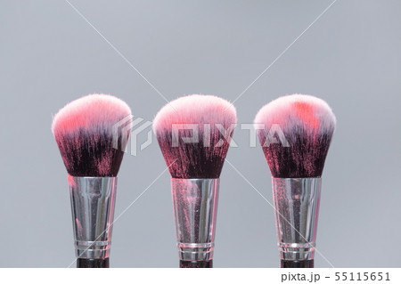 Powder brushes on light background with pink powder splash close up Powder brushes on light background with pink powder splash close up 55115651