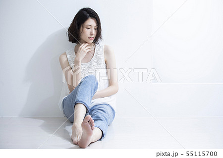 足を投げ出して座る若い女性の写真素材