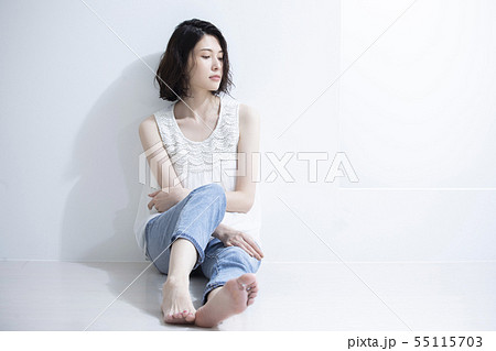 足を投げ出して座る若い女性の写真素材